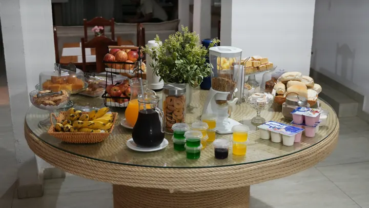 Mesa do café da manhã do Hotel Carvalho com frutas, sucos, pães e bolos